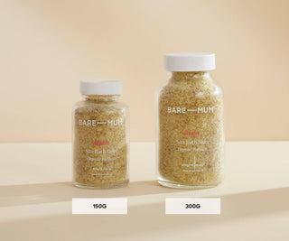 Two jars of Bare Mum sitz bath salts on a beige background. One is the 150g size, the other is the 300g size jar. 