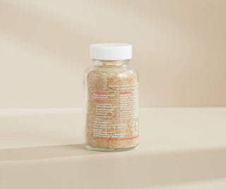 Glass jar with a white lid on a beige background.