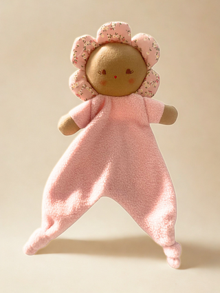 Pink plush toy with a flower-shaped head on a beige background.